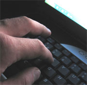 A laptop, hand typing