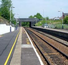 A deserted rail platform, station announcements not heard